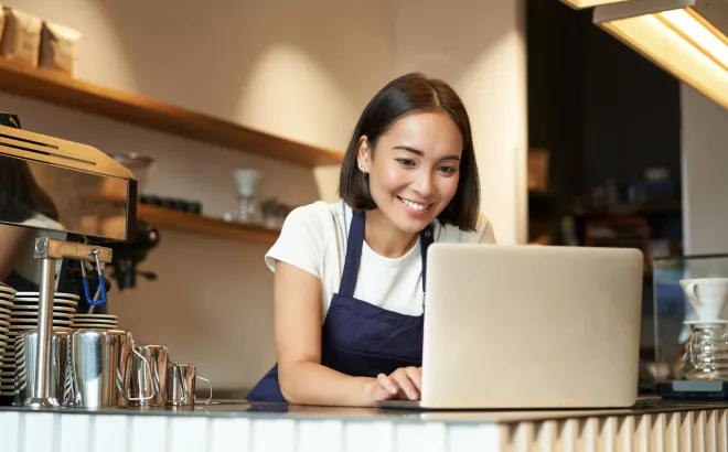 Glimlachende werkende student in een koffiebar